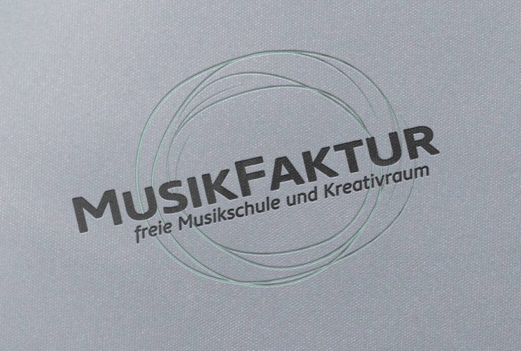 Logo der MusikFaktur, bestehend aus ineinandergreifenden kreisförmigen Linien über dem Text „MusikFaktur freie Musikschule und Kreativraum“ auf einem hellgrauen strukturierten Hintergrund, entworfen von einem talentierten Webdesigner aus Aachen.