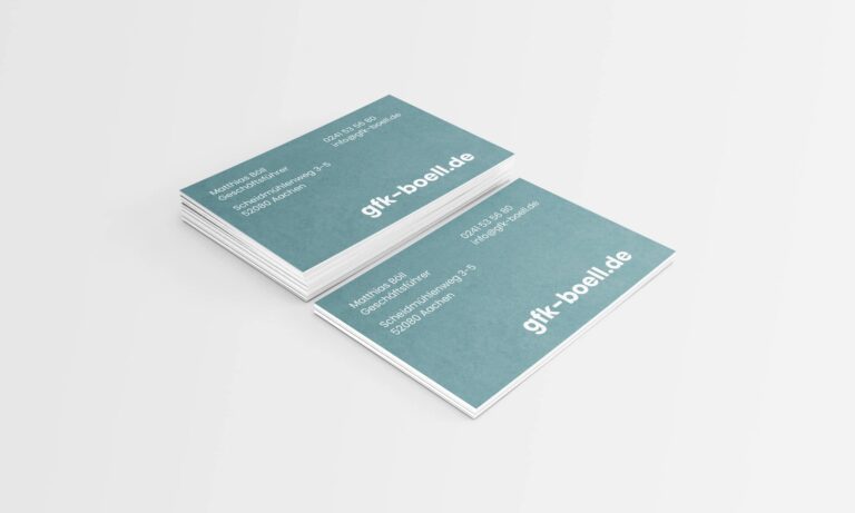 Gezeigt wird ein Stapel blauer Visitenkarten mit weißem Text. Die Karten enthalten Kontaktdaten von Matthias Buhr und einer Organisation, „gfk-boell.de“, einschließlich E-Mail-Adressen, Telefonnummern und einer Postanschrift in Deutschland. Der Hintergrund ist schlicht weiß und wurde von Printdesign Aachen erstellt.